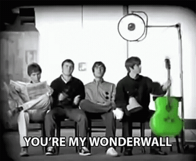A Group Of Men Are Sitting In Chairs With A Green Guitar And The Words You 'Re My Wonderwall Above Them . GIF