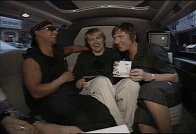 A Group Of Men Are Sitting In The Back Seat Of A Limousine Laughing And Drinking Coffee . GIF