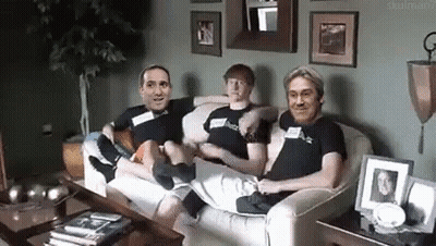 A Group Of Men Are Sitting On A Couch In A Living Room . GIF