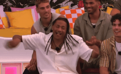 A Group Of Men Are Sitting On A Couch Laughing And Having Fun . GIF