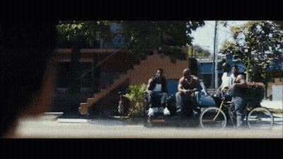 A Group Of Men Are Sitting On The Side Of A Street GIF