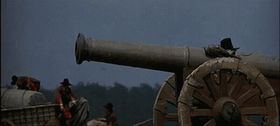 A Group Of Men Are Standing Around A Cannon That Is Firing GIF