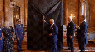 A Group Of Men Are Standing Around A Large Black Cloth That Says Ap GIF