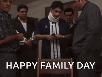 A Group Of Men Are Standing Around A Man With A Neck Brace And The Words Happy Family Day Written On The Bottom GIF