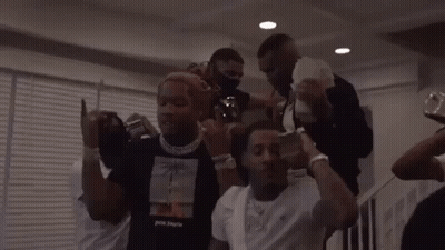 A Group Of Men Are Standing Around Each Other Holding Money . GIF