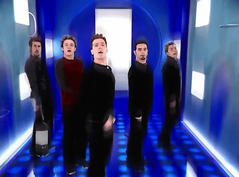 A Group Of Men Are Standing In A Blue Hallway Dancing GIF