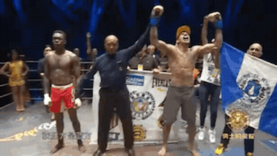A Group Of Men Are Standing In A Boxing Ring And One Of Them Is Holding A Flag GIF