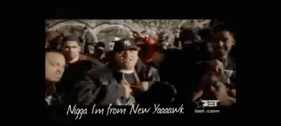 A Group Of Men Are Standing In A Crowd And One Of Them Is Wearing A Hat That Says Ny On It . GIF