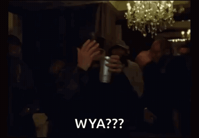 a group of men are standing in a dark room holding a cup and clapping .