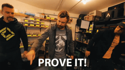 A Group Of Men Are Standing In A Garage And One Of Them Is Pointing To The Word Prove It GIF