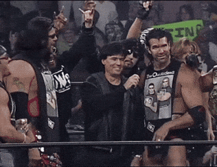 A Group Of Men Are Standing In A Ring With One Wearing A Shirt That Says Dw On It GIF