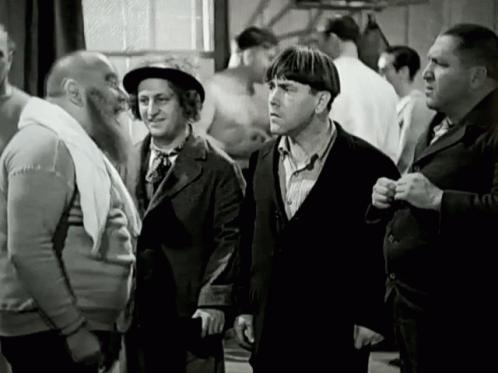 A Group Of Men Are Standing In A Room And One Of Them Has A Beard GIF