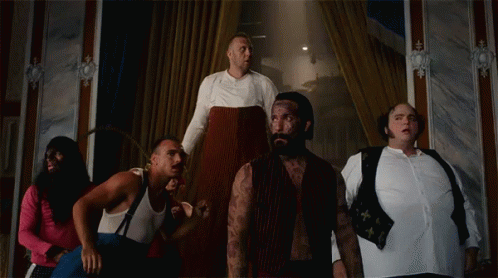 A Group Of Men Are Standing In A Room And One Of Them Has A Tattoo On His Arm GIF