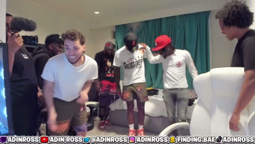 A Group Of Men Are Standing In A Room And One Of Them Is Wearing A Shirt That Says ' Grosscrew ' GIF