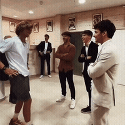 A Group Of Men Are Standing In A Room Talking GIF