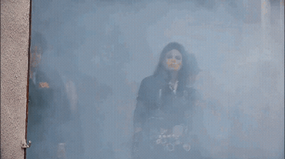 A Group Of Men Are Standing In A Room With Smoke Coming Out Of The Door GIF