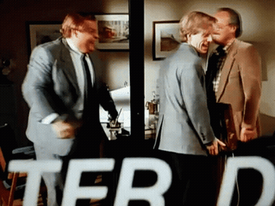 A Group Of Men Are Standing In A Room With The Word Terd In The Corner GIF
