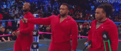 A Group Of Men Are Standing In A Wrestling Ring . GIF