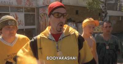 A Group Of Men Are Standing In Front Of A Building And One Of Them Is Saying Booyakasha GIF