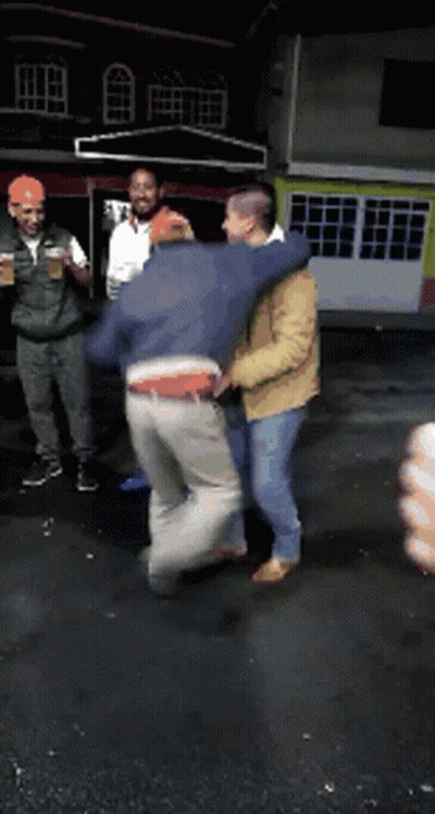 A Group Of Men Are Standing In Front Of A Building Holding Drinks GIF