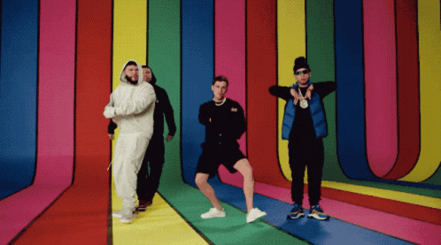 A Group Of Men Are Standing In Front Of A Colorful Wall GIF