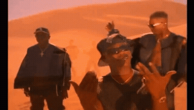 A Group Of Men Are Standing In Front Of A Desert . GIF
