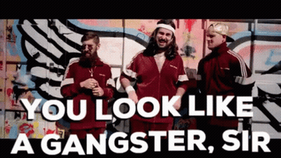 A Group Of Men Are Standing In Front Of A Graffiti Wall With The Words You Look Like A Gangster Sir GIF