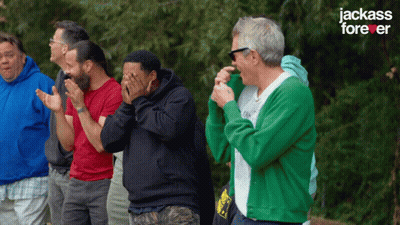 A Group Of Men Are Standing In Front Of A Jackass Forever Sign GIF