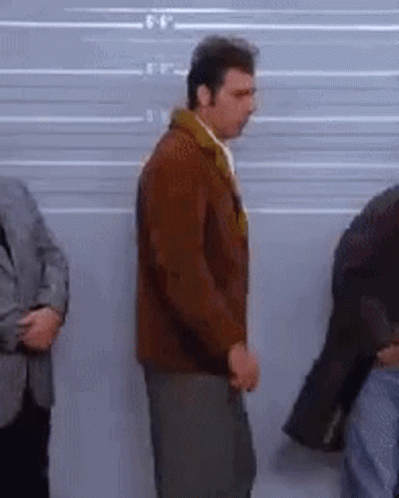 A Group Of Men Are Standing In Front Of A Police Line Up . GIF