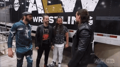 A Group Of Men Are Standing In Front Of A Truck That Says Wrestling GIF