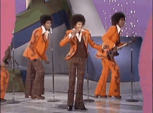 A Group Of Men Are Standing In Front Of Microphones On A Stage . GIF