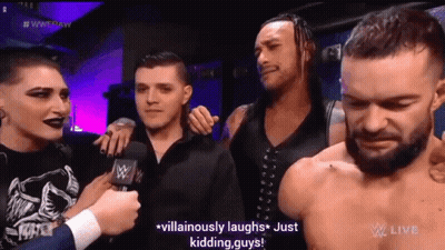A Group Of Men Are Standing Next To Each Other And Laughing While A Man Talks Into A Microphone . GIF