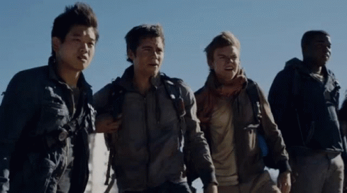 A Group Of Men Are Standing Next To Each Other And One Has A Backpack On His Back GIF