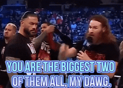 A Group Of Men Are Standing Next To Each Other And One Of Them Is Holding A Microphone And Says You Are The Biggest Two GIF