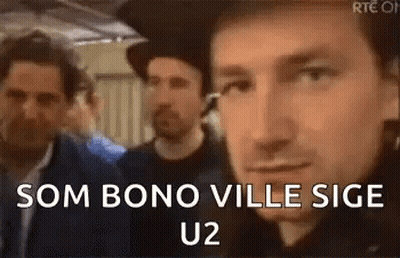 A Group Of Men Are Standing Next To Each Other And One Of Them Is Wearing A Hat And Smiling . GIF