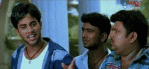 A Group Of Men Are Standing Next To Each Other And One Of Them Is Wearing A White Shirt GIF