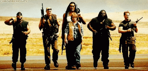 A Group Of Men Are Standing Next To Each Other Holding Guns In The Desert . GIF