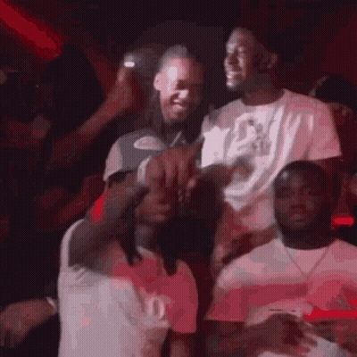 A Group Of Men Are Standing Next To Each Other In A Crowd At A Party . GIF