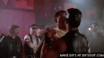 A Group Of Men Are Standing Next To Each Other In A Dark Room . GIF