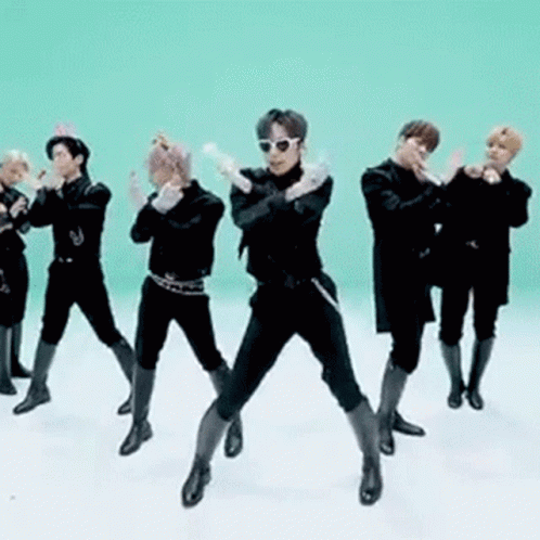 A Group Of Men Are Standing Next To Each Other In A Line And Dancing In Front Of A Green Background . GIF