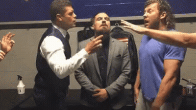 A Group Of Men Are Standing Next To Each Other In A Locker Room . One Of The Men Is Wearing A Suit . GIF
