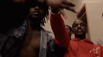 A Group Of Men Are Standing Next To Each Other In A Room . GIF