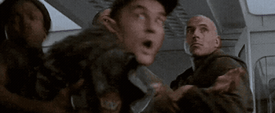 A Group Of Men Are Standing Next To Each Other In A Room And One Of Them Is Holding A Knife . GIF
