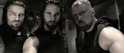 A Group Of Men Are Standing Next To Each Other In A Room . GIF