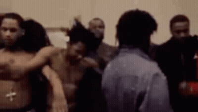 A Group Of Men Are Standing Next To Each Other In A Room Without Shirts On . GIF