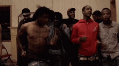 A Group Of Men Are Standing Next To Each Other In A Room Without Shirts . GIF