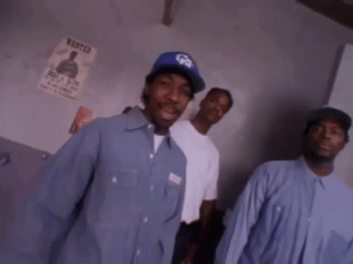 A Group Of Men Are Standing Next To Each Other In A Room . GIF