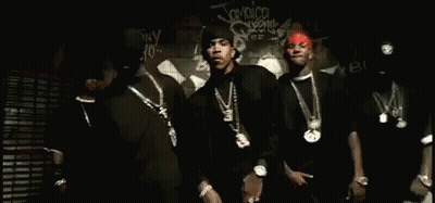 A Group Of Men Are Standing Next To Each Other In Front Of A Graffiti Wall . GIF