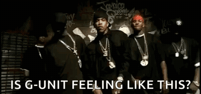 A Group Of Men Are Standing Next To Each Other In Front Of A Wall With Graffiti On It . GIF