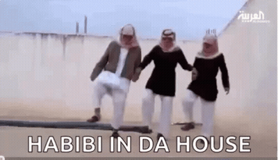 A Group Of Men Are Standing Next To Each Other In The Desert Holding Hands And Dancing . GIF